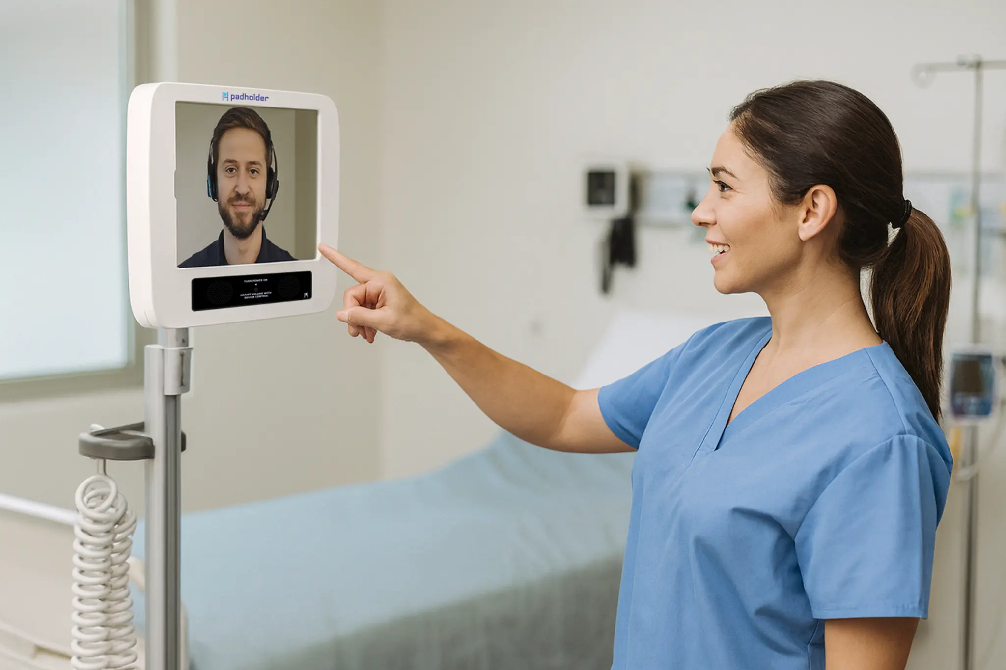 Clinician using a Padholder telehealth cart to speak with a remote care team member